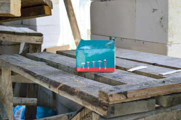 box with fasteners stands on old construction wooden scaffolding