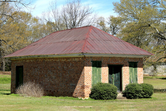 A rustic old southern weathered red brick rusted  tin roof garden shed building