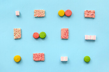 Crispy rice bars with sweets on color background