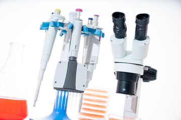 microscope, petri dishes and pipette stand by microbiological laboratory