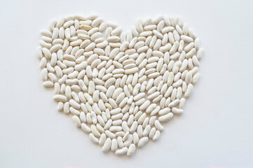 heart shaped white beans. A lot of beans stock together to form a shape.
