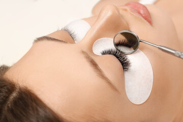 Eyelashes extensions. Fake eyelashes. Eyelash extension procedure.Close up portrait of woman eye...