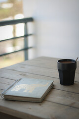 notebook and coffee cup on a wooden table