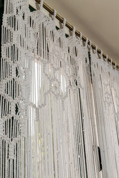 Part of handmade macrame white  curtain on the window  