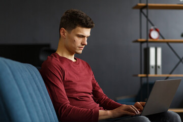 Young freelancer working in home with laptop. Texting messages, browsing internet. Studying online, online education, remote working. Young people working at home. Business concept.