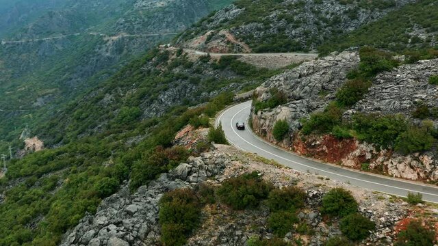 Wild mountain road in Croatia, Aerial view as car travels winding road