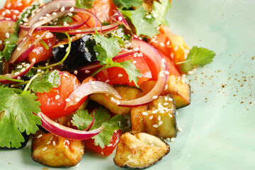 eggplant salad with sesame seeds and tomatoes closeup