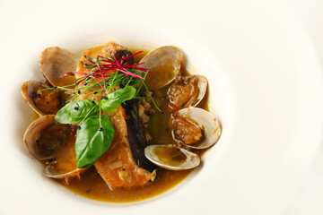 steamed mussels with salmon in white plate with white wine closeup. Classic French or American restaurant appetizer