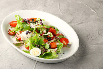 vegetarian caesar with cherry and bell pepper in white plate on concrete background