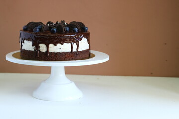 biscuit cake with cream cheese and chocolate topping with fresh berries closeup. Creamy cheesecake with chocolate cookies and cream biscuits. dessert isolated on black