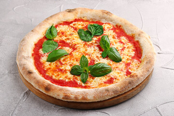 Pizza Margherita with tomatoes, Basil and Mozzarella Cheese closeup on light concrete table or stone background