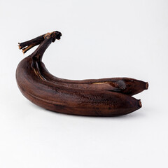 on a white background. No isolation. The banana turned black. Long-term storage, spoiled. Close-up.
