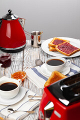 Close up photo of kitchen table with .appliances, kitchenware with toasts and jams