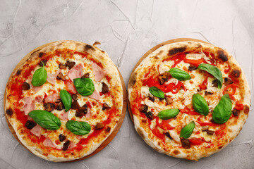 set of two pizza on light concrete or stone table top view. pizza with mushrooms and chicken or hum