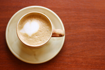 capuccino with crema top view on wood background with latte art