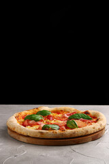 pizza prosciutto with basil and Mozzarella closeup on light concrete or stone background