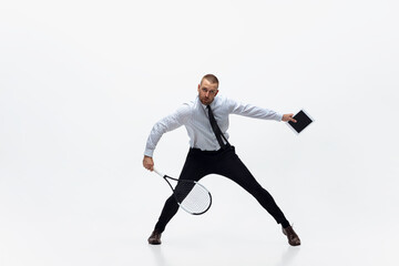 Fototapeta na wymiar Time for movement. Man in office clothes plays tennis isolated on white studio background. Businessman training in motion, action. Unusual look for sportsman, new activity. Sport, healthy lifestyle.