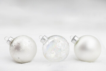 Original photograph of three glass Christmas tree ornaments of silver and white lined up in the snow