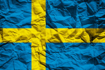 National flag of Sweden on crumpled paper. Flag printed on a sheet. Flag image for design on flyers, advertising.