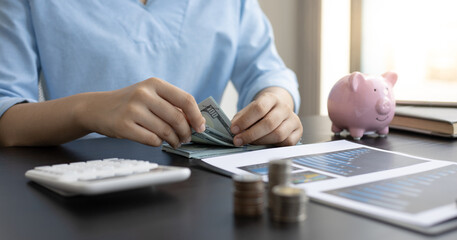Fototapeta premium Man counting dollar bills on the desk.