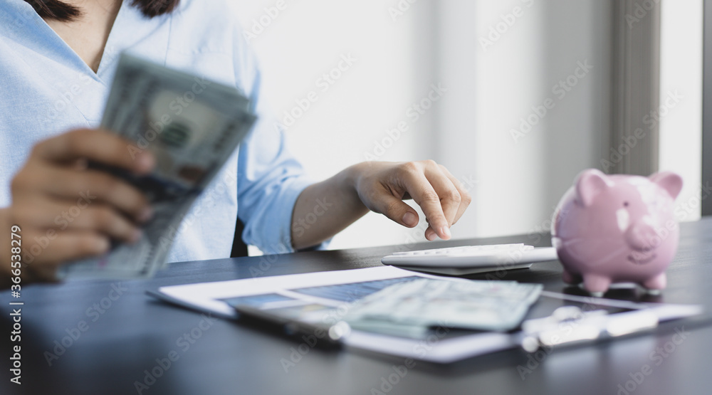 Wall mural asian women are calculating family income and expenses in their home office.