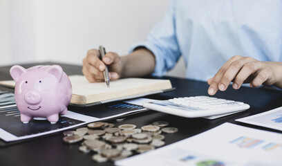 Asian women are calculating family income and expenses in their home office.