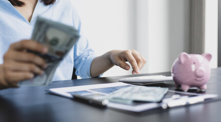 Asian women are calculating family income and expenses in their home office.