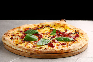jalapeno pizza with sausages close up on gray concrete or stone table and black background for copy space