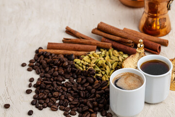 Cup of coffee with roasted beans, seeds and cinnamon
