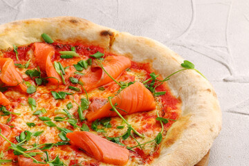 salmon pizza with green close up on gray concrete or stone table top view.