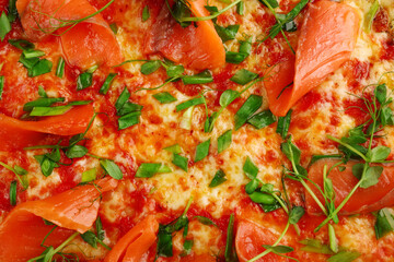 salmon pizza with green close up on gray concrete or stone table top view. pizza background