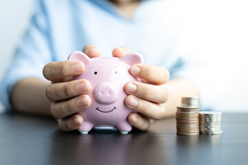 Girl is carrying a piggy bank to save money.