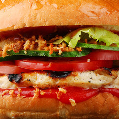 tasty burger background with chicken close up on dark isolated background. Homemade hamburger or burger with fresh vegetables and sauce