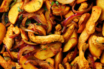 frying pan with potatoes meat and roast onion close up on black concrete background. mexican food concept. potatoes fried in a pan top view. food background.