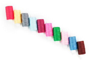 Sewing threads of different colors on reels on a white background. Free space, close-up. Isolate