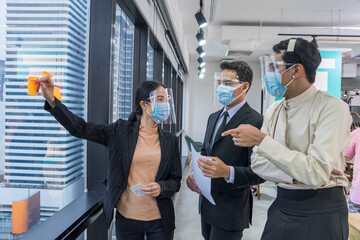  Group of advertising company employees wear masks and face shield and creative brainstorming...