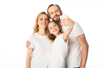 happy family in white t-shirts taking selfie on smartphone isolated on white