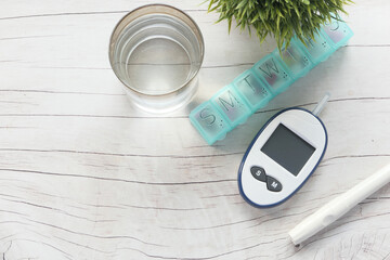 Top view of diabetic measurement tools and pill on table 