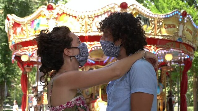 Europe, Italy , Milan - 
engaged couple with mask kissing outdoors in a park after the end of the quarantine at home for Covid-19 Coronavirus outbreak - finish of lockdown and social distance 1 meter