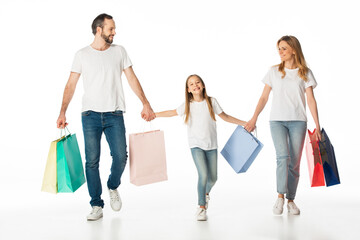 Fototapeta na wymiar cheerful family walking with colorful shopping bags and holding hands isolated on white