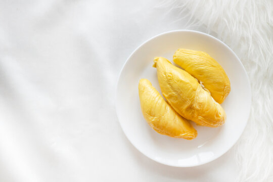 Durian Flatlay On White Background With Copy Space. A Plate Of Durian On A White Table. Top Down Shot Of The King Of Fruits.