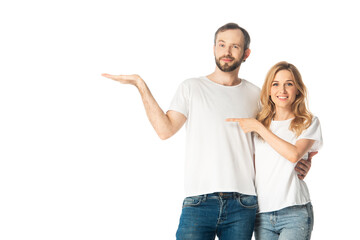 smiling adult couple in white t-shirts pointing with hand and finger aside isolated on white