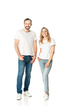 full length view of adult couple in white t-shirts and jeans posing isolated on white