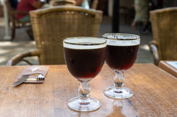 Glasses with cold dark strong Belgian beer served outdoor