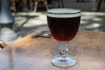 Glasses with cold dark strong Belgian beer served outdoor
