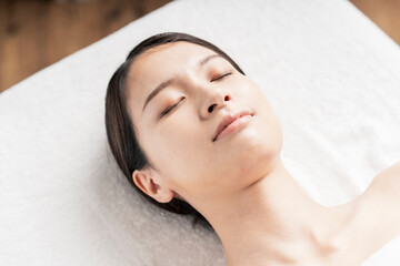 Fototapeta na wymiar Relaxed face of young woman lying down in beauty salon