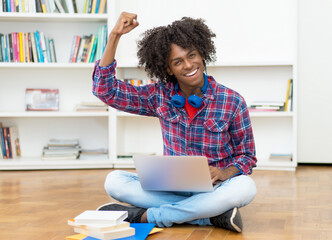 Successful african american young adult with computer