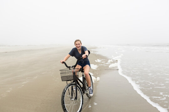 Teenage girl riding a bike on sand at the beach, St. Simon's Island Georgia