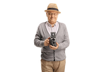 Elderly man recording with a vintage 8 mm camera recorder