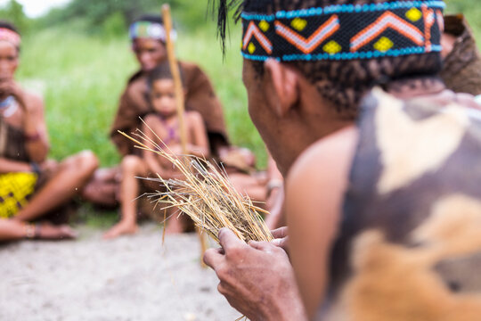 San People, a bushman creating fire from dry kindling, a cultural demonstration.